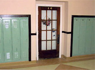 Exterior View: Retention of glass doors along historic corridor by incorporating new, code compliant doors on the interior.