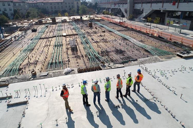 photo of seven workers in hard hats and high viz vests at a construction site