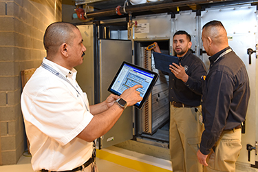 facility managers - 3 men, one with a tablet - at USIP