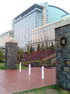 Image of the front of Gaylord National Hotel and Convention Center, National Harbor, MD with white bollards along brick path between stone pillars and hotel in background