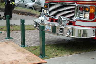three collapsible by apparatus bumper force bollards with a fire truck about to knock into them
