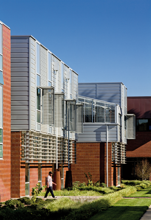 Exterior of backside of Chemeketa Community College Health Sciences Complex building with man walking Chemeteka Comm College