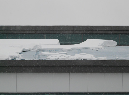 Snow breaking off and sliding from a roof