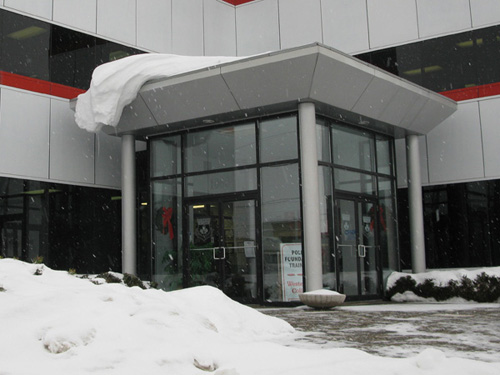 Drifting snow hanging from the corner of a building entrance