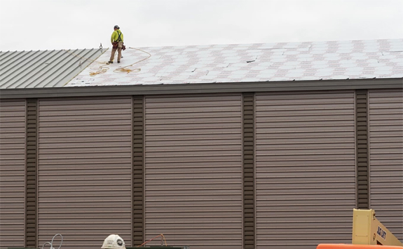 working standing on roof during roof installation