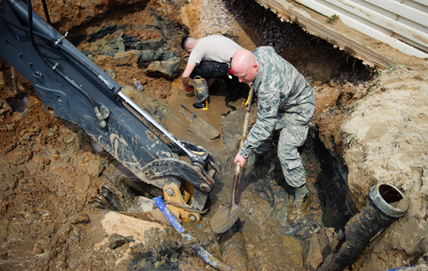 Senior Airman Casey Reed, 8th Civil Engineer Squadron water and fuel systems maintenance shop technician, removes mud from the area around a broken pipe at Kunsan Air Base, Republic of Korea