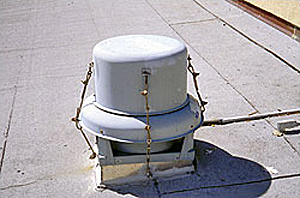 Cowling attached to the curb with cables to overcome blow-off of the fan coiling
