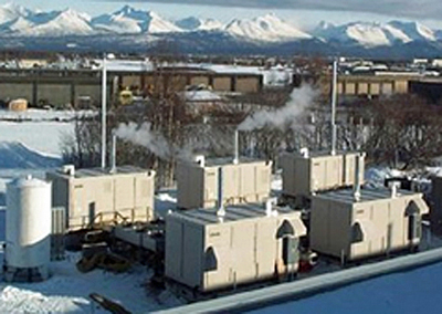 Photo of a mail processing center in Anchorage, Alaska. The photo shows five 200 kilowatt phosphoric acid fuel cells with mountains in the background.