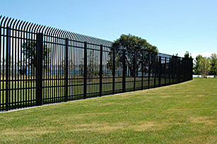 Long view of a vehicle barrier fence surrounding a grassy area