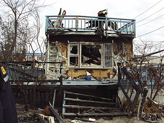 House showing the effects of wind and flood damage leading to fire