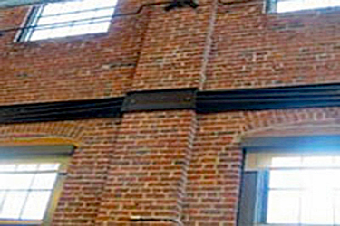 horizontal metal strapping on long expanses of masonry