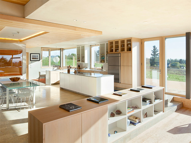 photo of interior space in the Karuna House, Portland Housee including the kitchen and meals area and low bookcase as room divider