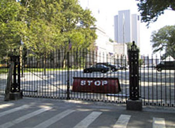 Entrance gate with a rotating wedge vehicle barrier displaying the word stop