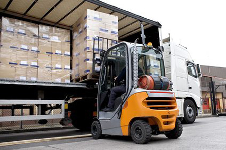 Forklift driver unloading goods from a truck