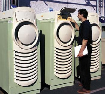 Photo of three microturbines with a man inspecting the one in the center