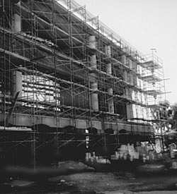 black and white photograph of a building beng renovated with all the outside walls removed