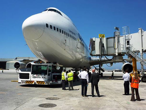 A photo of a trial at LAX international Airport where an airplane was pulled into a new gate to test the locations of fuel pits and to make sure the boarding bridges reach the doors.