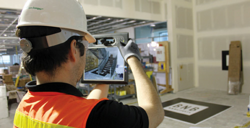 Worker using an electronic to monitor interior construction 