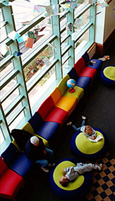 The children's area of Des Plaines Public Library featuring a wall of windows