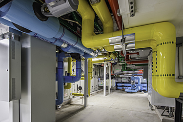 Basement Mechanical Room after restoration with color coded piping jacketing