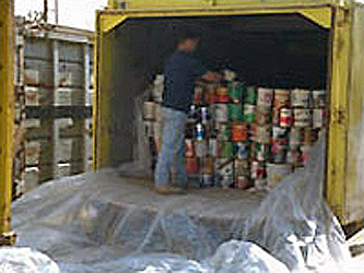 Photo of a man stacking latex paint cans into the back of truck for recycling